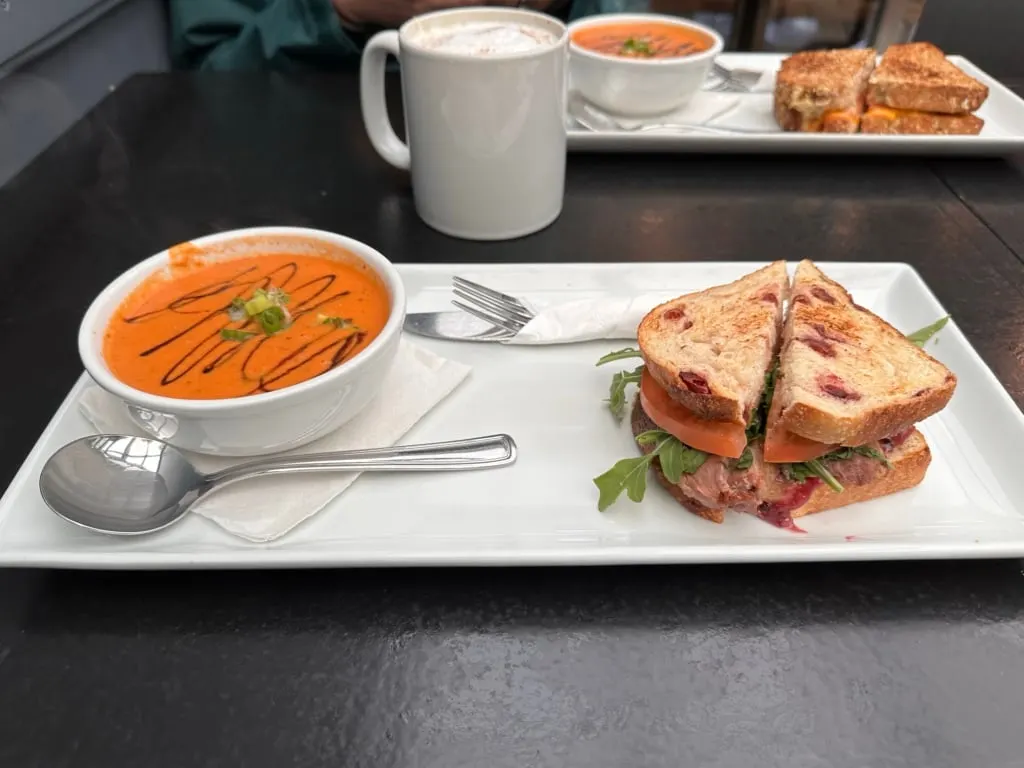 A bowl of soup and a sandwich on a white tray at Muddy Waters Cafe in Harrison Hot Springs, BC