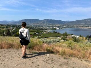 A woman enjoys the view of Penticton from Munson Mountain - one of the best things to to in Penticton in the summer
