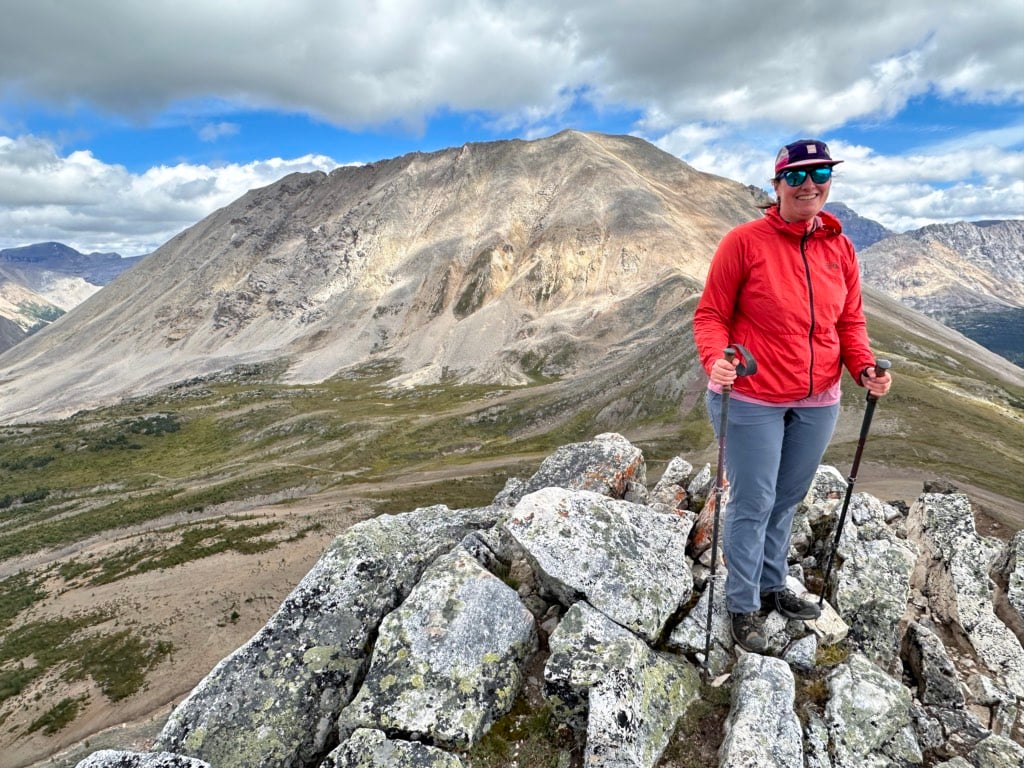 A hiker standing on the summit of Packer's Peak with Deception Pass in the background.