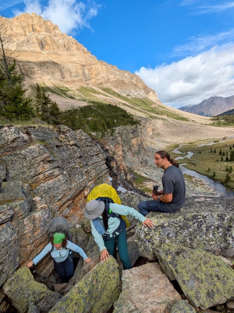 Hikers climbing out of the chimney near Myosotis Lake.