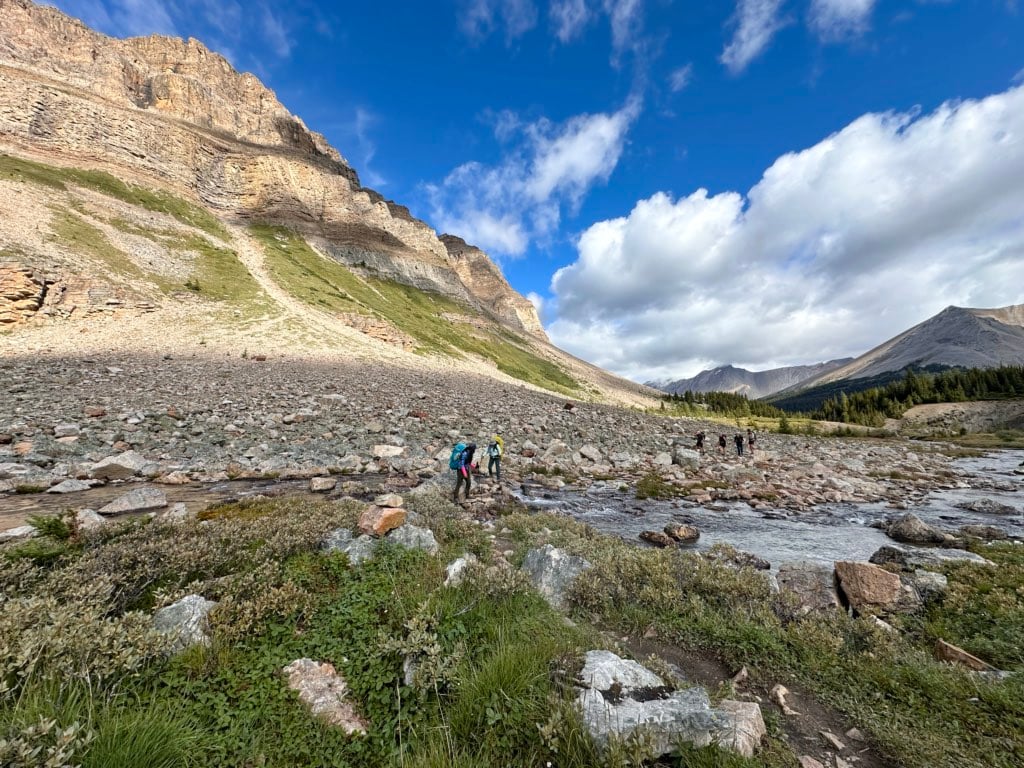 Hikers cross a creek on the Packer's Pass Trail