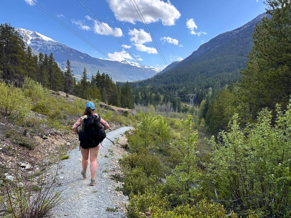 A hiker walks under the powerlines on the Sea to Sky Trail