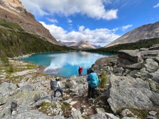 A group of hikers at Myotosis Lake on the Skoki Loop in Banff National Park
