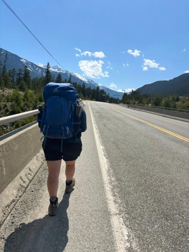A hiker walks on the Sea to Sky Highway