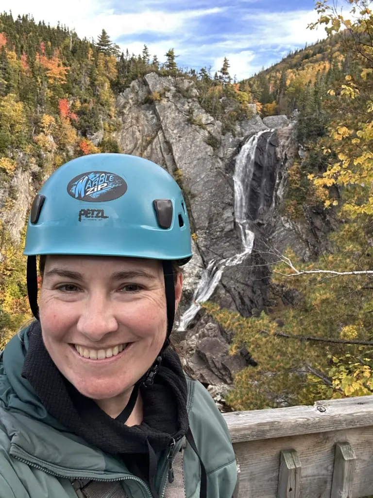 A woman takes a selfie in front of Steady Brook Falls during a tour with Marble Zip Tours
