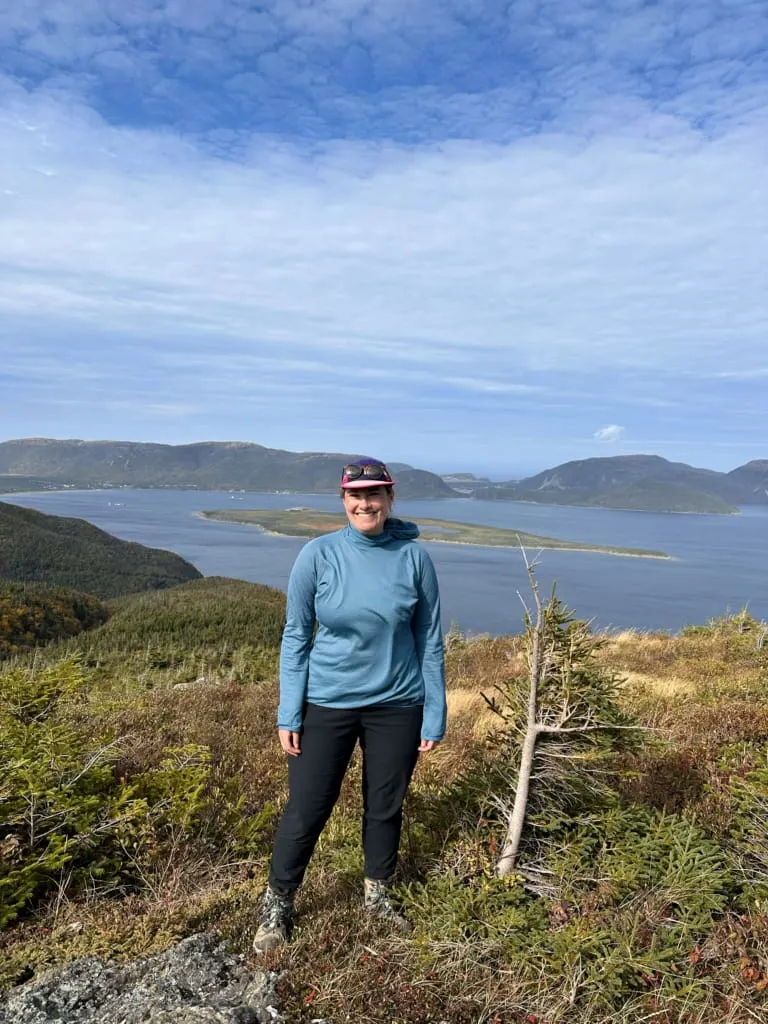 A hiker wears the Mountain Hardwear Airmesh Hoody on Cape Blow Me Down in Newfoundland
