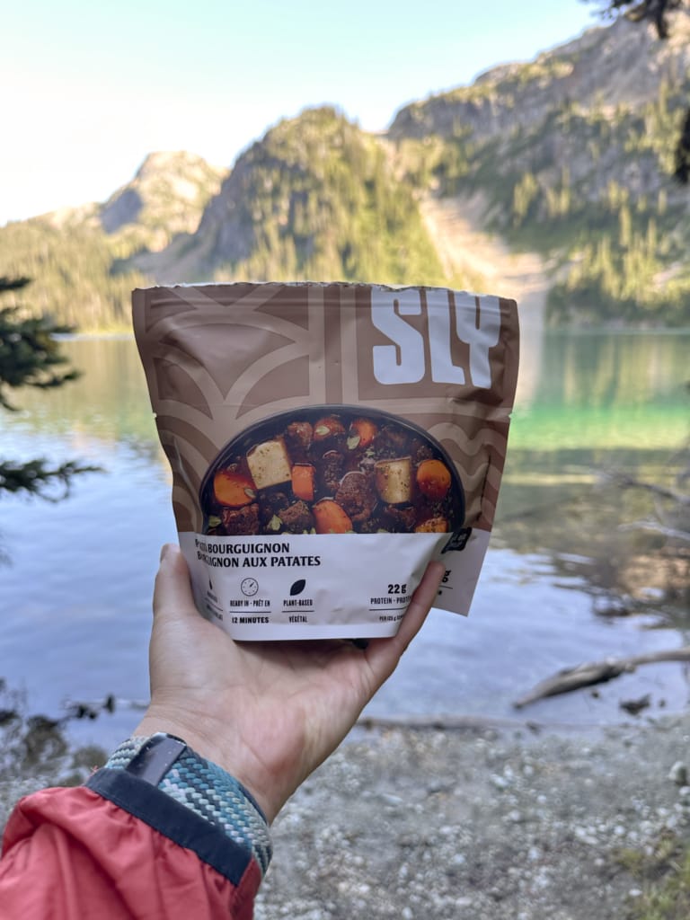 A hiker holds a package of SLY Potato Bourguignon