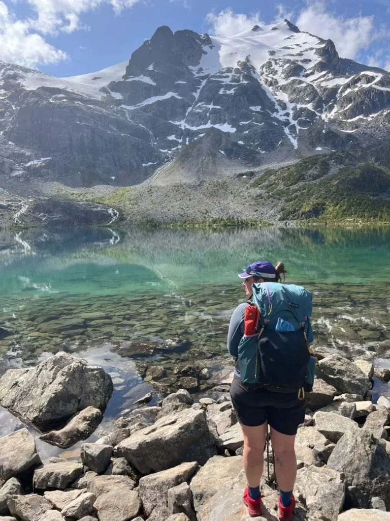 A hiker wears the Gossamer Gear Mariposa Pack at Joffre Lakes