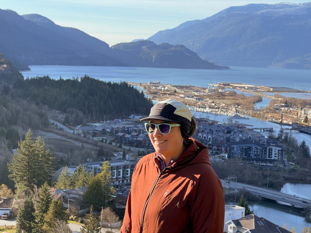A hiker wears the Ciele GOCap LTWND on a hike in Squamish