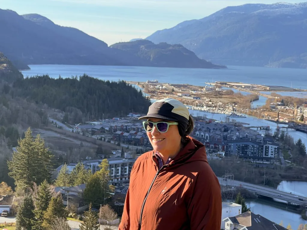 A hiker wears the Ciele GOCap LTWND on a hike in Squamish