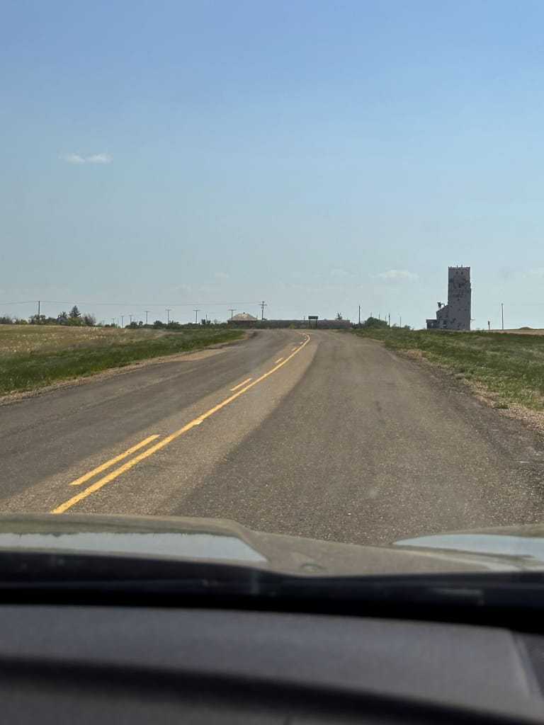 View through the windshield of a small Saskatchewan highway