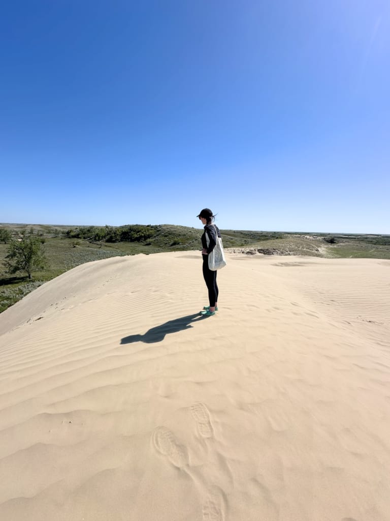 A woman stands on a sand dune at Great Sand Hills in Saskatchewan