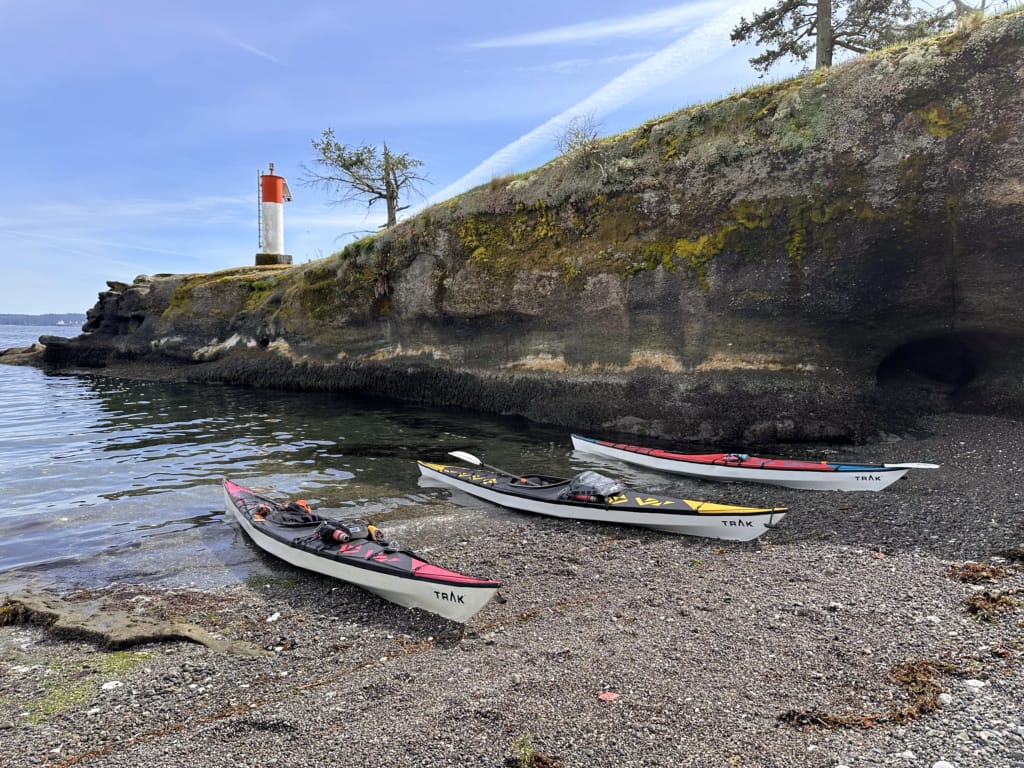 Three kayaks on a beach on a small island in Departure Bay