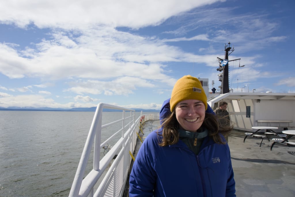A woman smiles on the outside deck of a BC Ferry