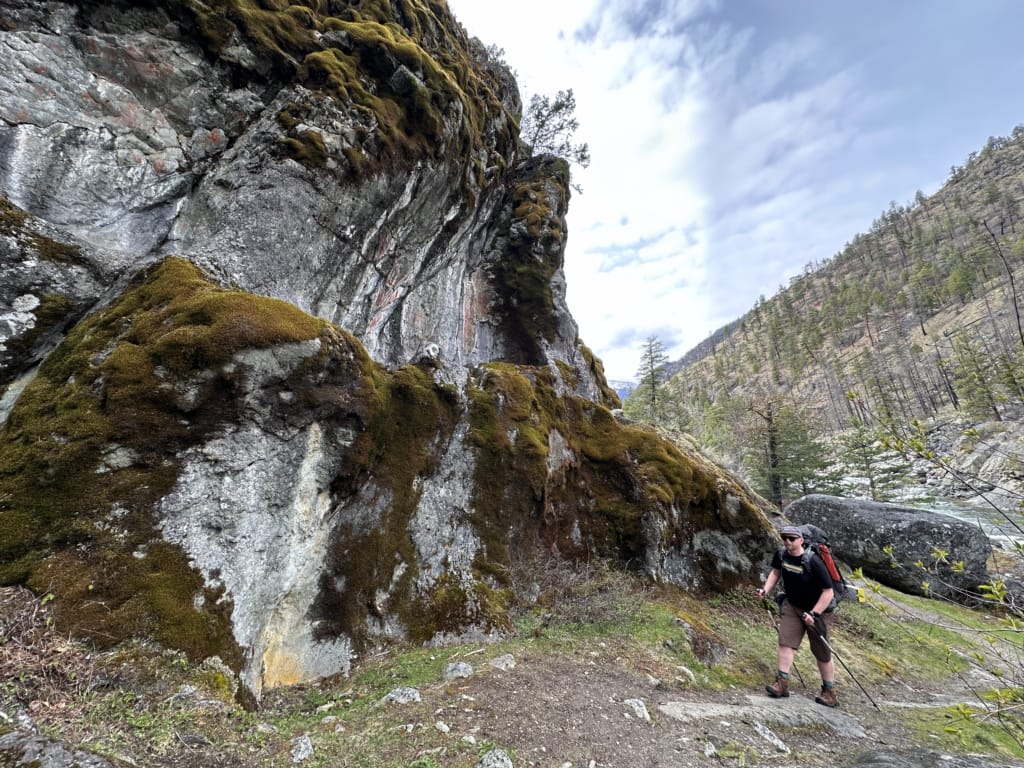 A hiker pause at the Asking Rock in the Stein Valley