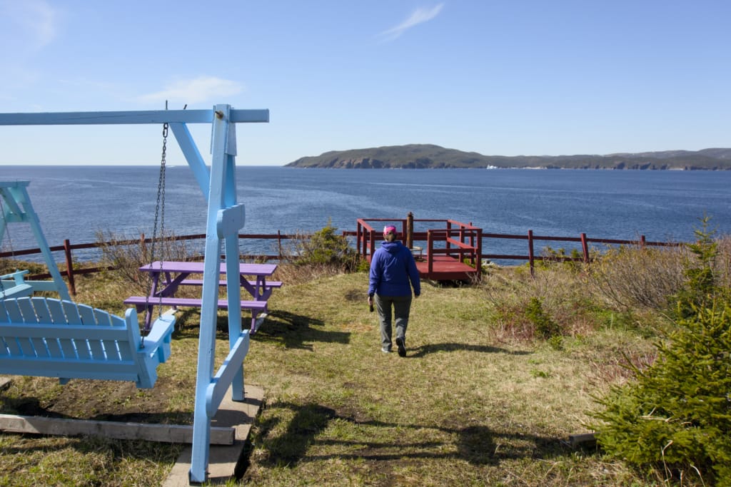 A hiker walks towards a viewing platform on the Barr'd Island Trail in Englee, Newfoundland