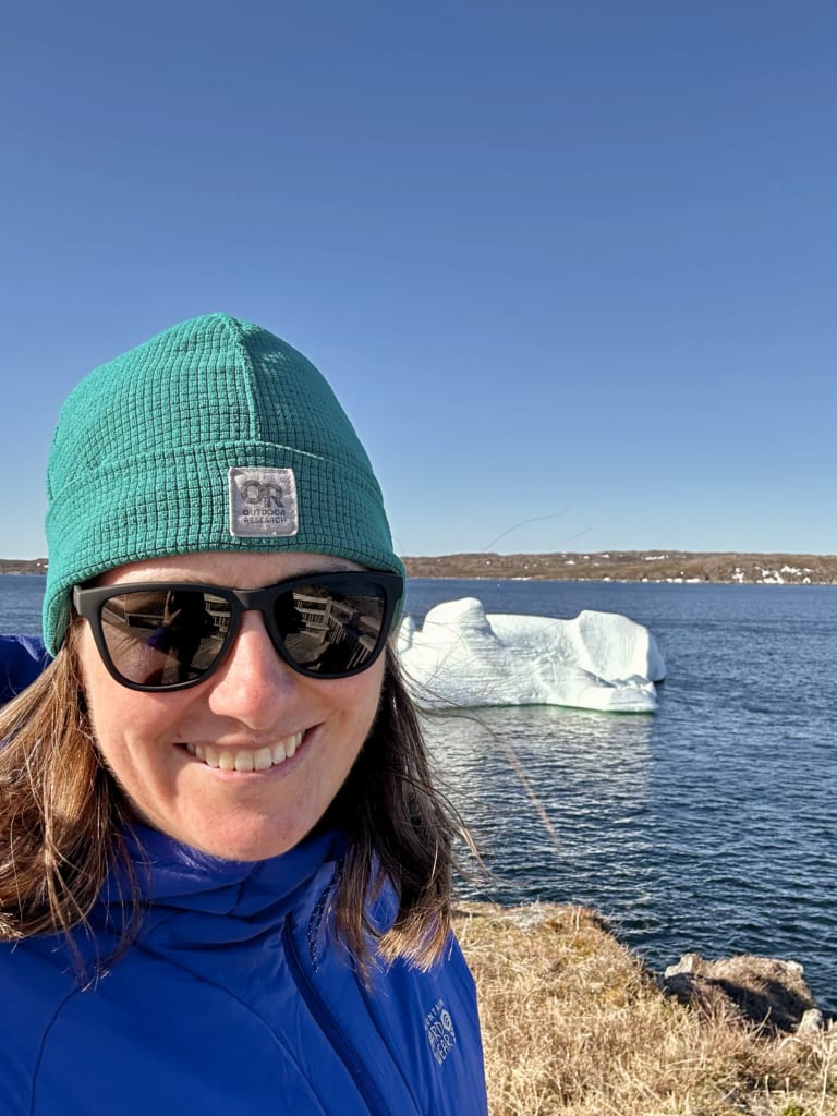 A woman takes a selfie with an iceberg in St. Anthony, Newfoundland
