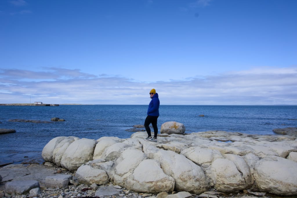 A woman walks on the thrombolites rock formations in Newfoundland