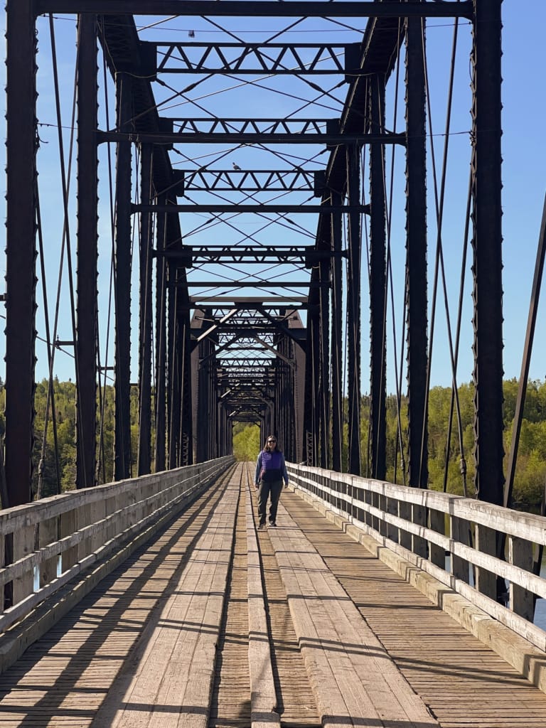 A woman walks across the historic trestle in Bishop's Falls