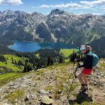 A hiker walks along an alpine ridge high above Tenquille Lake near Pemberton