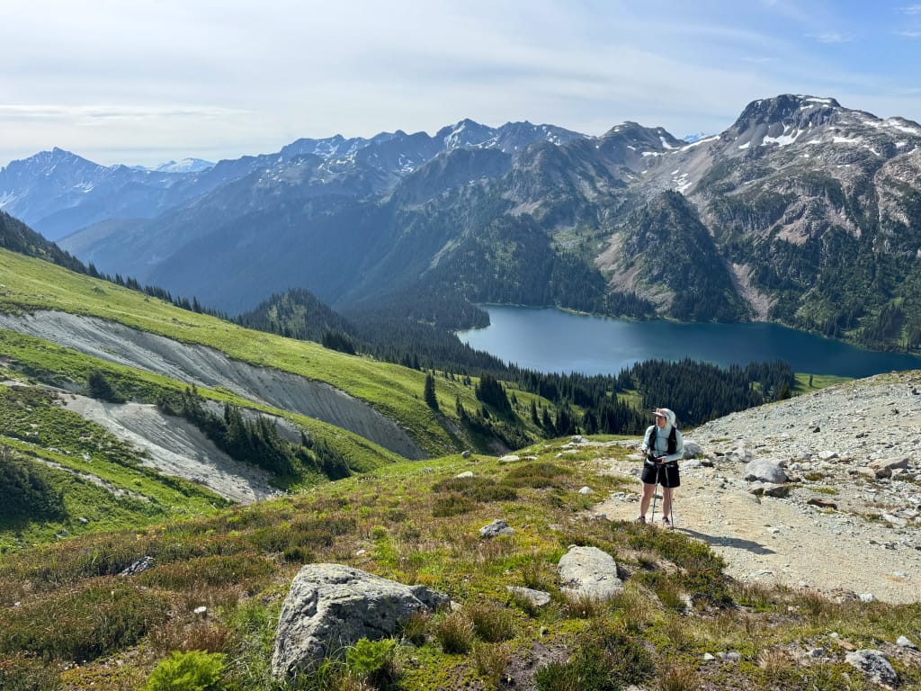 A hiker stands at the saddle between Tenquille Mountain and Finch Ridge