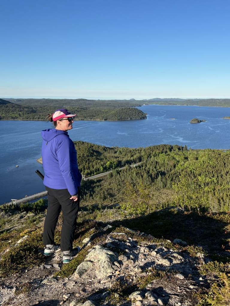 A woman stands on a rock at Mill Cove Viewpoint in Terra Nova National Park