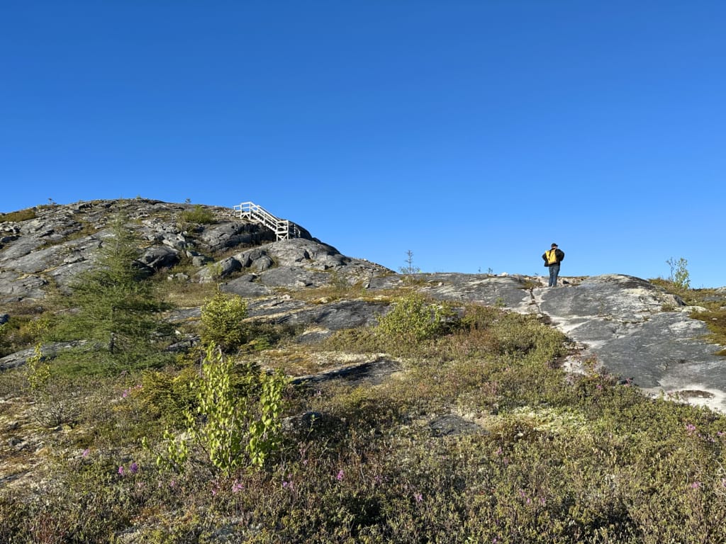 A hiker on the rocky Mill Cove Lookout Trail in Terra Nova National Park