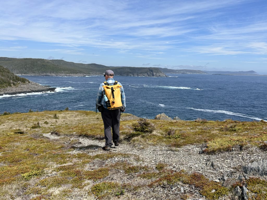 A hiker looks out to the ocean from the Spurwink Island Path near Port Kirwan, Newfoundland