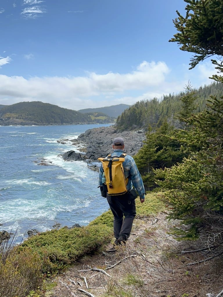 A hiker on a bluff above the ocean on the East Coast Trail