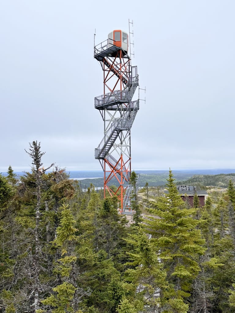 The Ochre Hill Fire Tower in Terra Nova National Park. It's a metal tower with staircases and a small building on top. 