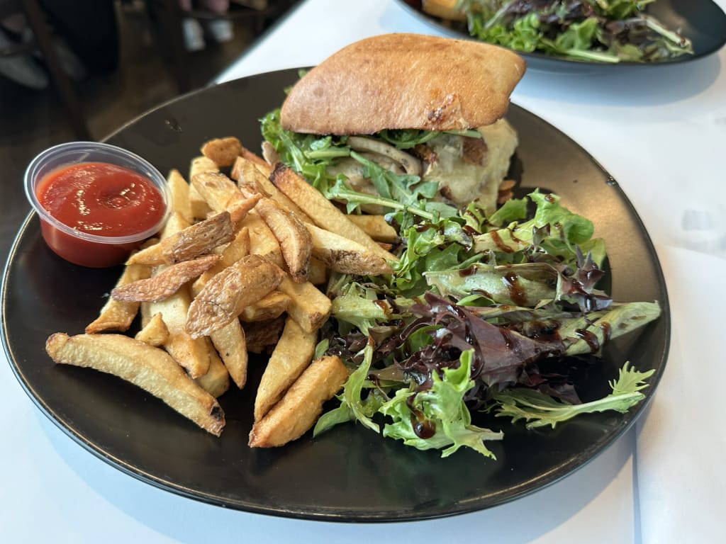 A sandwich with salad and fries at White Goose Bistro